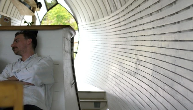 The small 25 square meter (269 square ft) home features intricate wooden flooring and curved surfaces