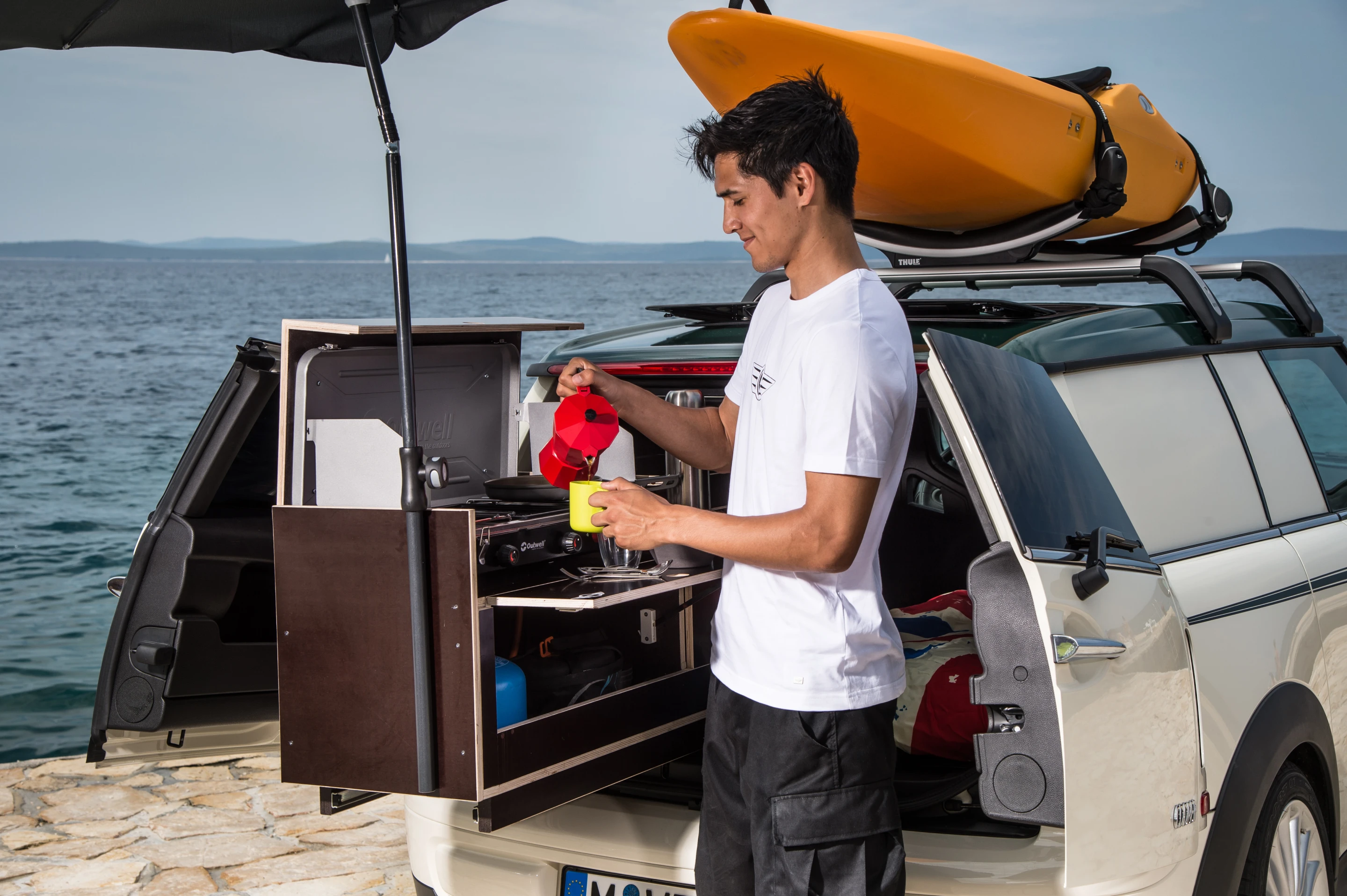 The space behind the driver's seat has been filled by a kitchenette which extends out of the Clubvan's pair of rear doors, and which includes a propane stove and a chest fridge