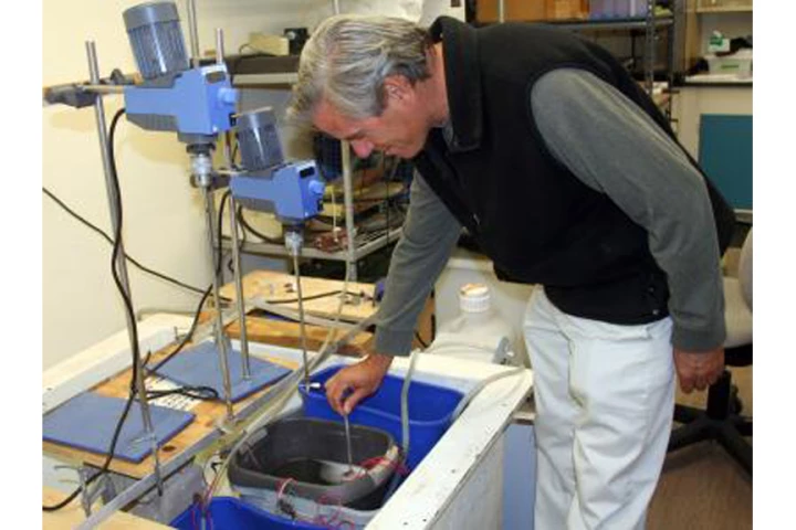 Bart Chadwick checks the condition in laboratory microbial fuel cells that may revolutionize naval energy use (Image: US Navy Photo by John F. Williams)