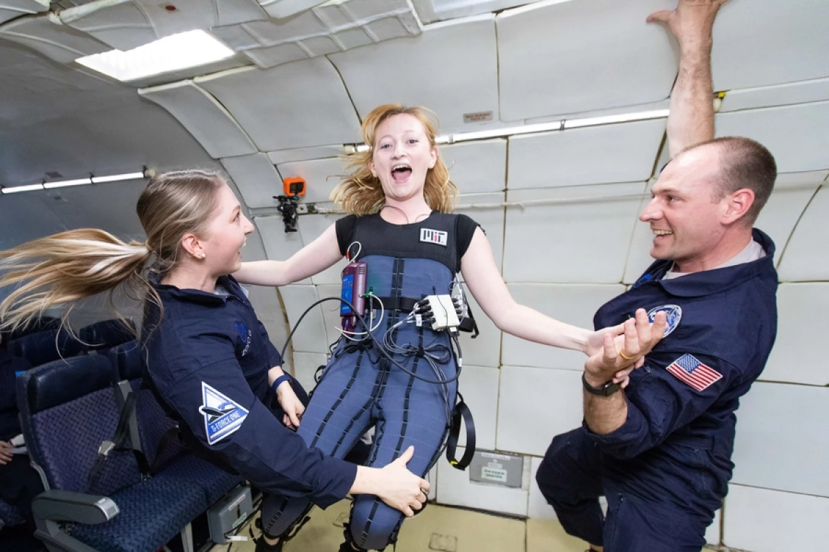 Rachel Bellisle (center) and Allison Porter (left) test the Gravity Loading Countermeasure Skinsuit on a parabolic flight