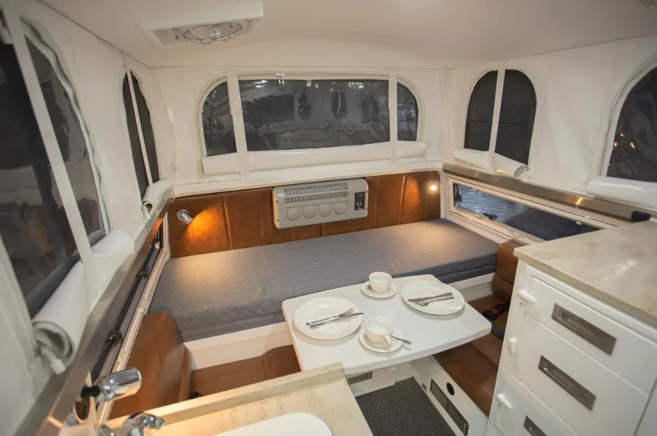 The EarthCruiser Escape features a full camper interior with wet bath, kitchen and convertible dinette/bed