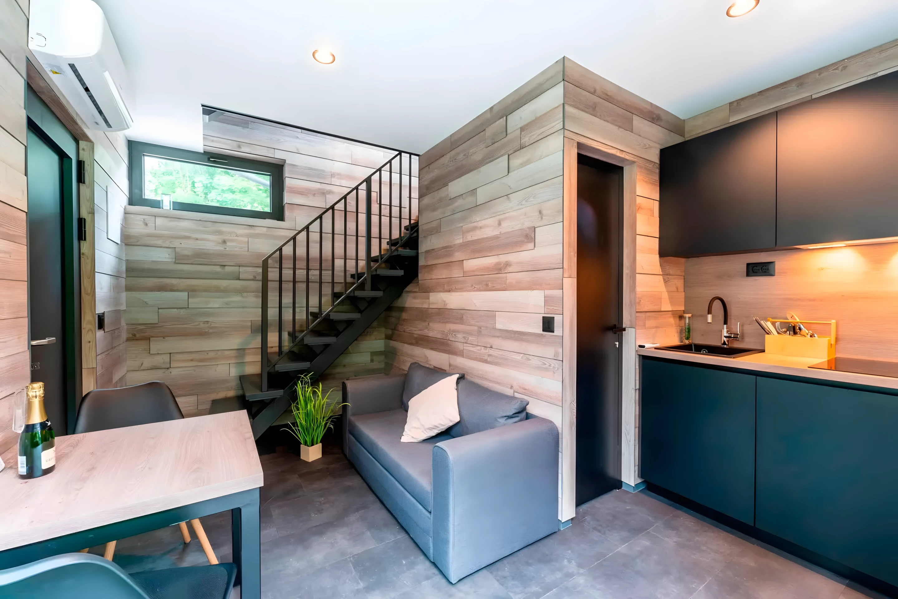 The DQ Tower's living room includes a sofa bed and a small dining table