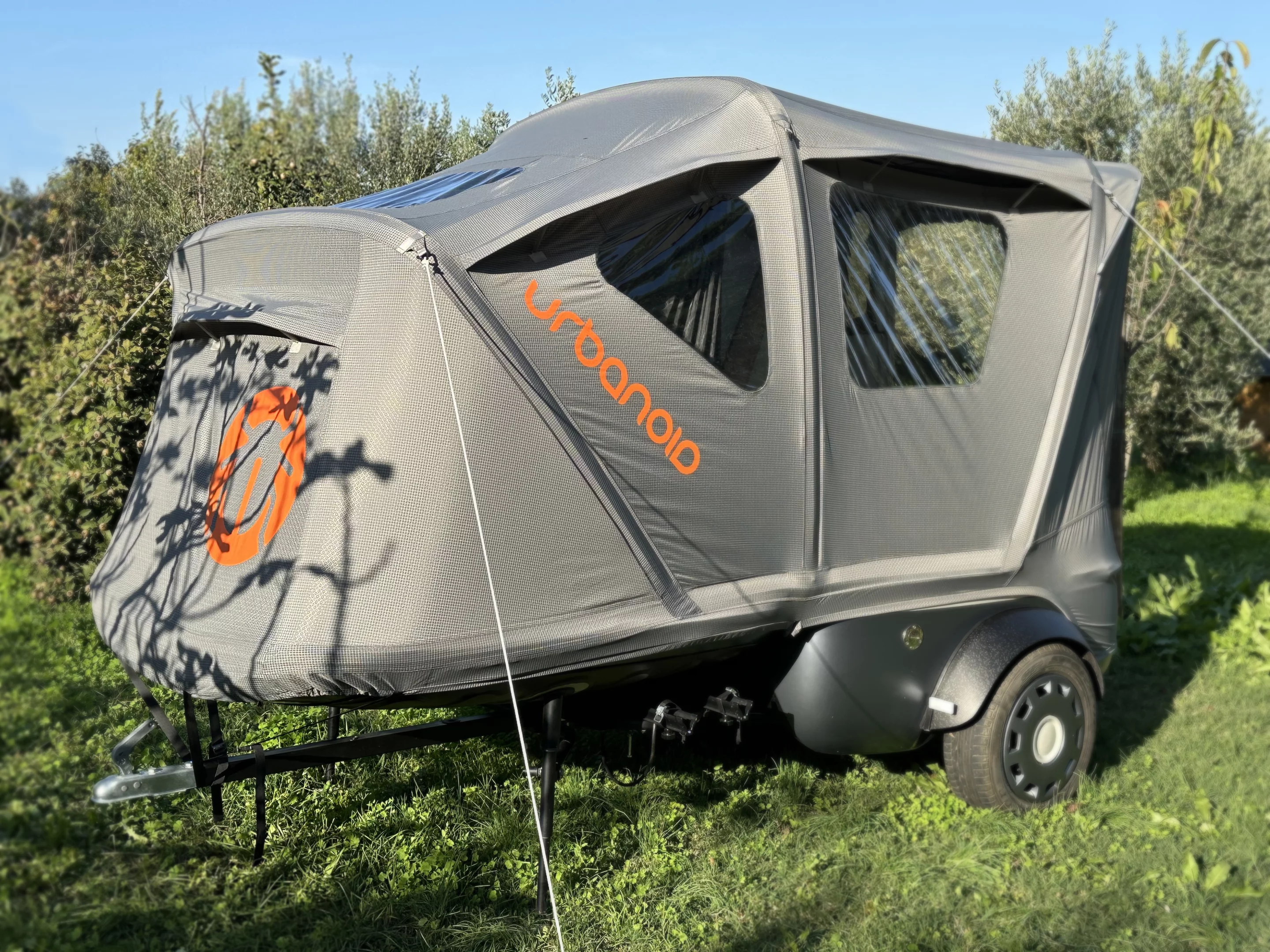 With a fold of the lid, securing of a few straps and guy lines, and inflation by hand or electric pump, the tiny Booba pod becomes a roomy tent
