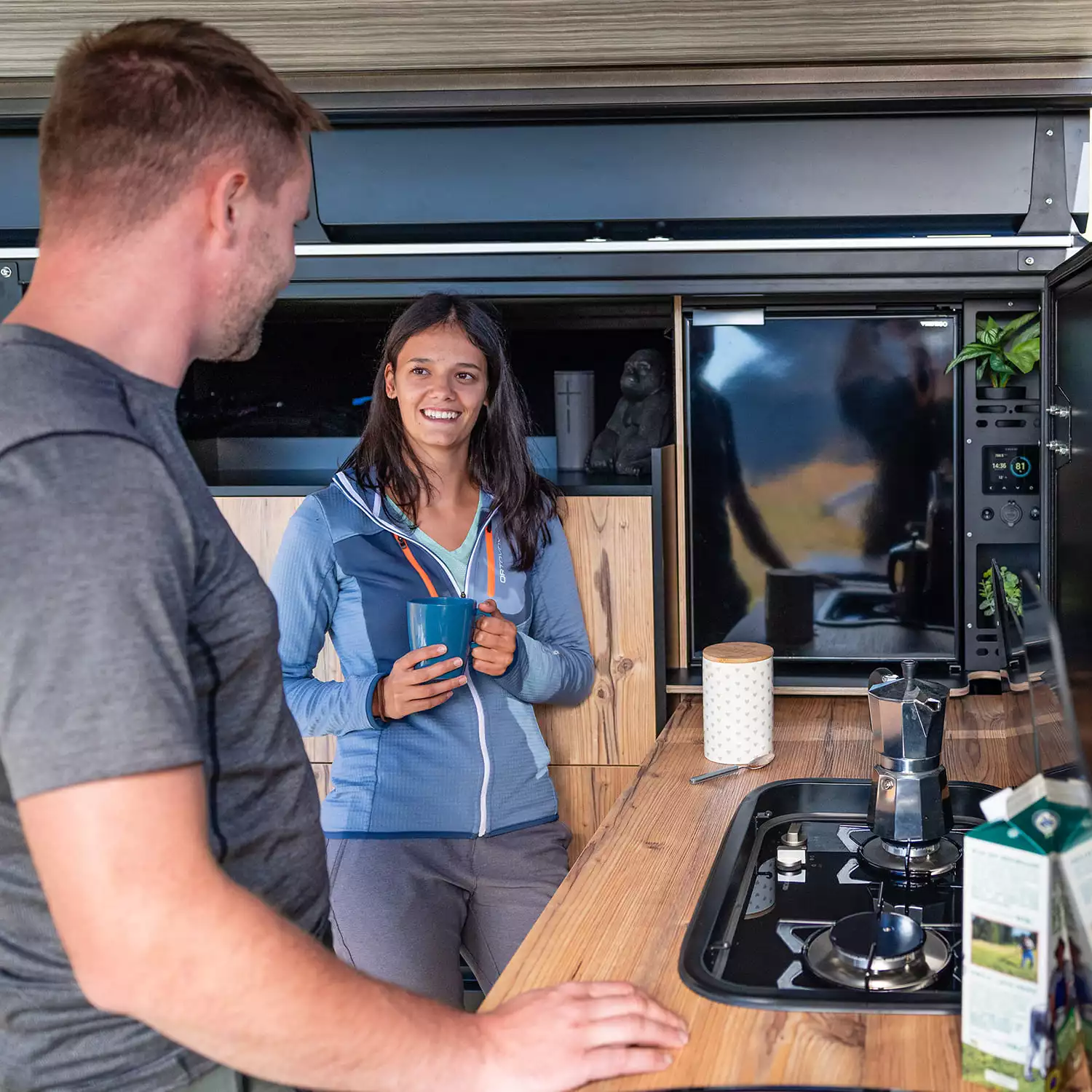 The kitchen area has room for a standing fridge and includes a dual-burner gas stove, sink and wood countertop with flip-up extension