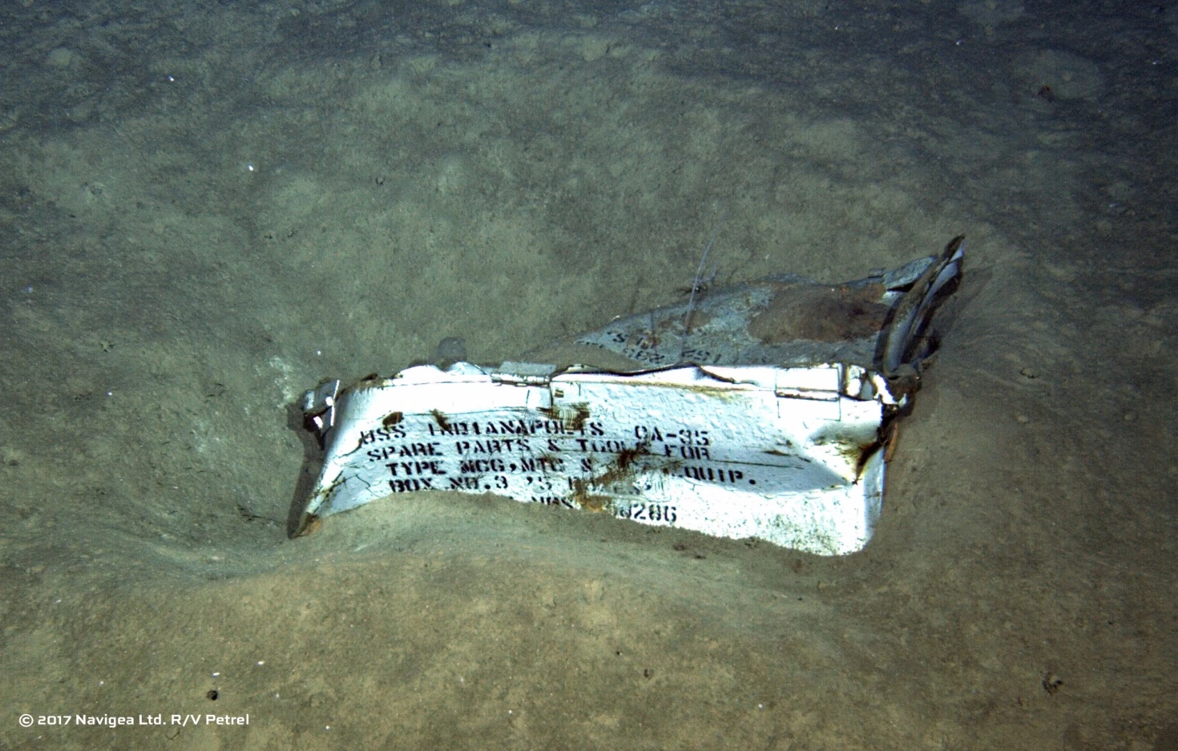 An image shot from a remotely operated underwater vehicle shows a spare parts box from USS Indianapolis on the floor of the Pacific Ocean in more than 16,000 feet of water