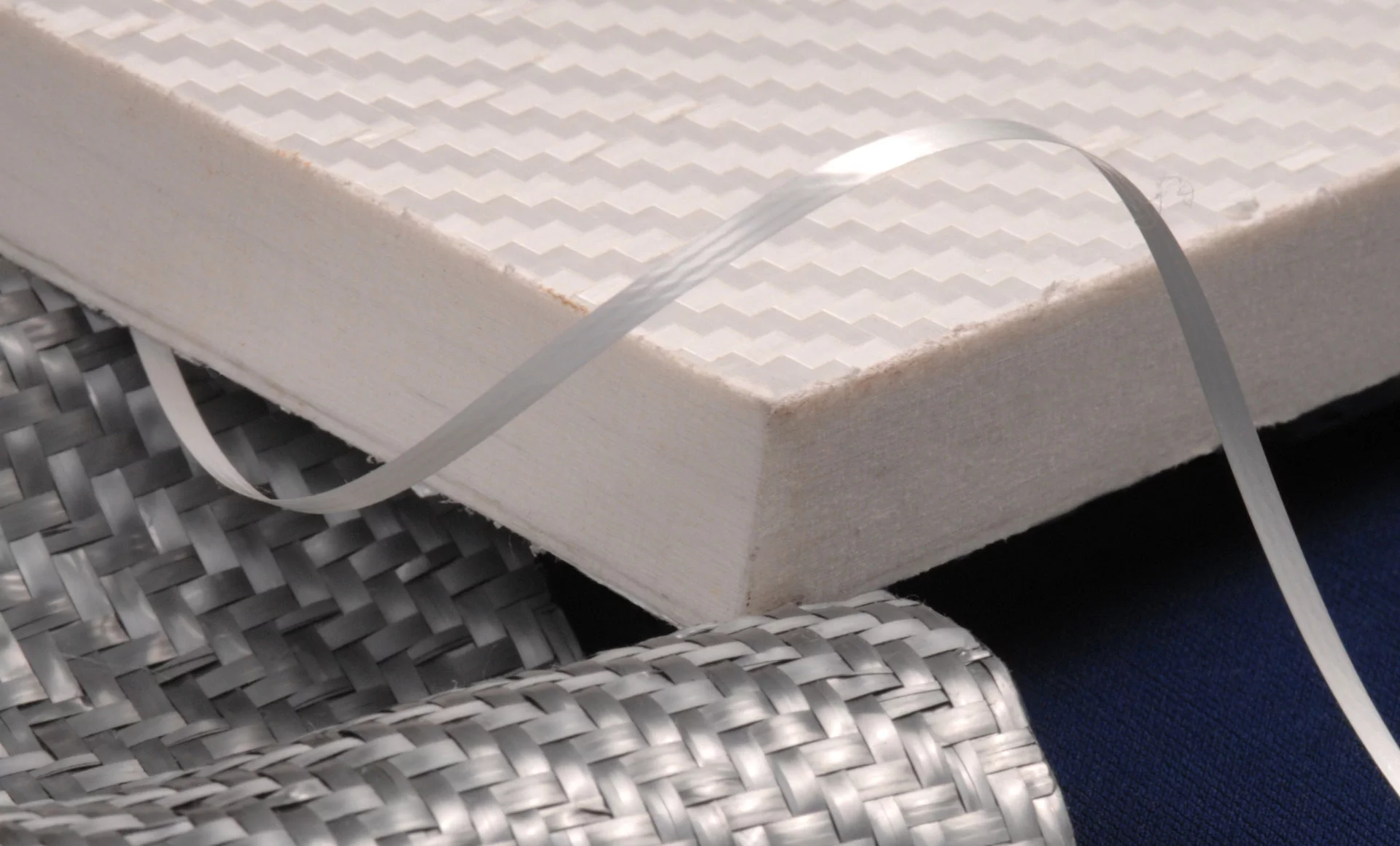 Whilst having similar properties to carbon fiber, Tegris won't shatter on impact, is approximately a tenth the cost, and is fully recyclable
