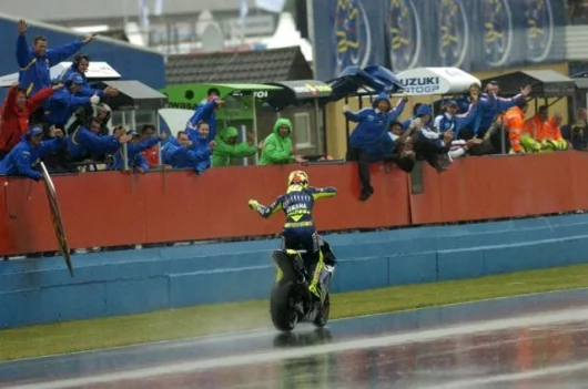 Valentino Rossi crosses the line to the repturous applause of all of the teams - his ride was, as he was perhaps signifying with his air violin, a virtuouso performance.