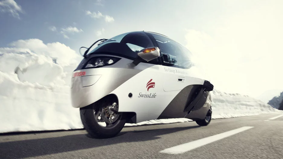 The Swiss Zerotracer is one of the most interesting enclosed, feet-forward motorcycle designs yet seen. The small frontal area of a motorcycle is one of the key reasons motorcycles are so fuel efficient (the other being a small motor), but when the generally poor aerodynamic drag coefficient of the motorcycle becomes a streamliner, it really can produce exceptional energy efficiency, as was proven when the Zerotracer won the around-the-world electric race in 2011.