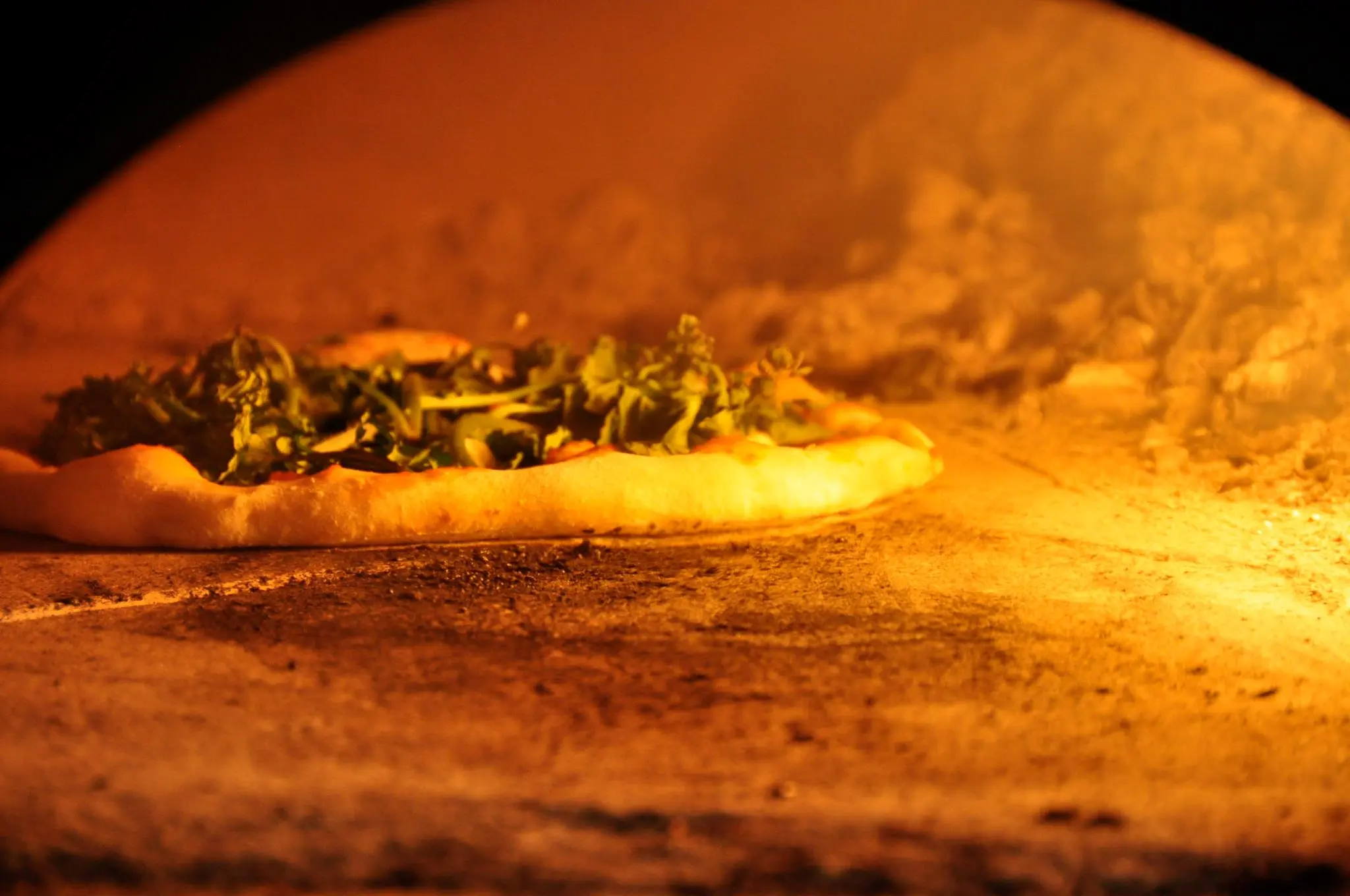 The smoldering temperatures reached inside a traditional wood-fired oven cooks the perfect pizza base in a matter of minutes