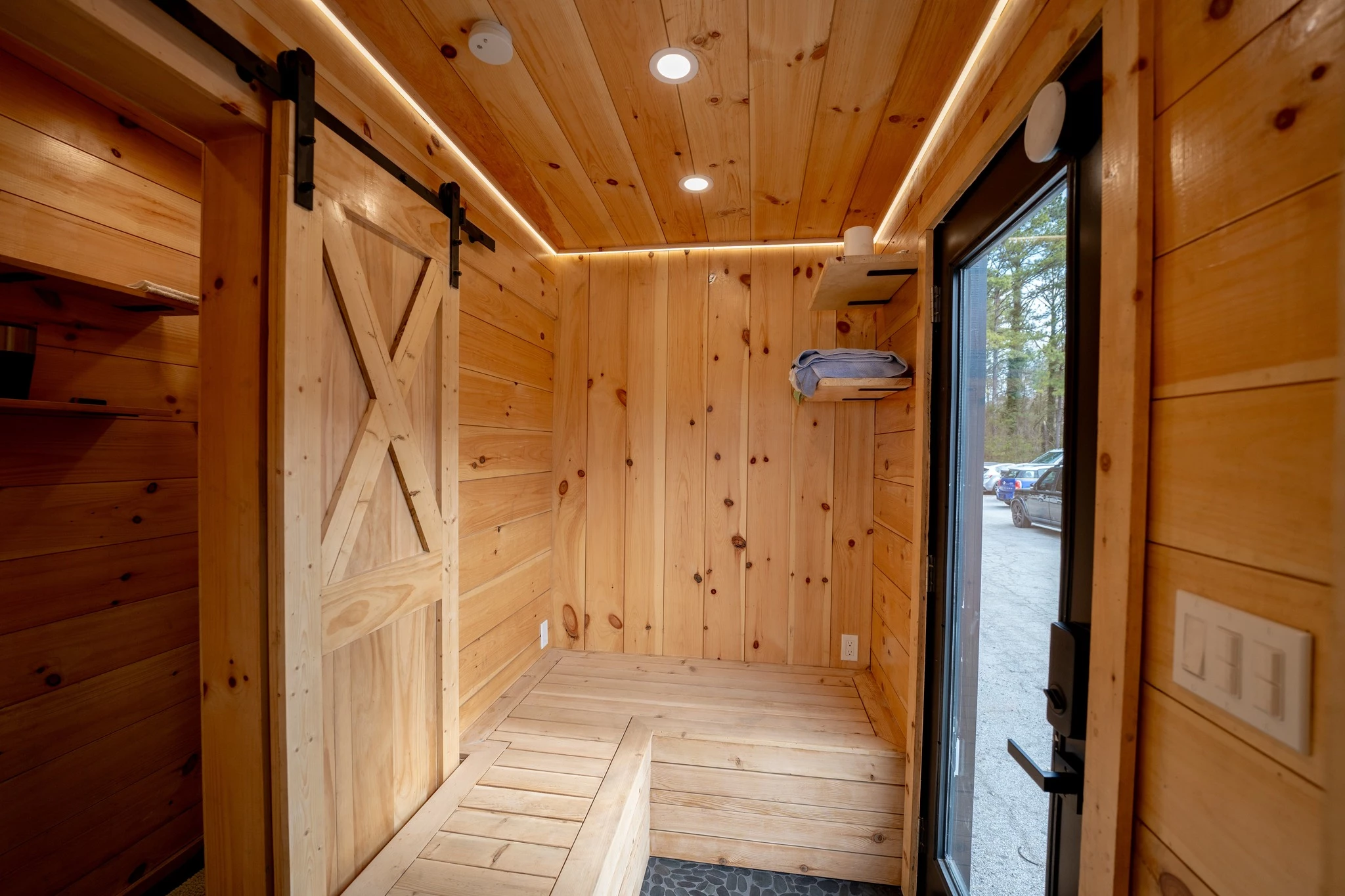 The tiny house sauna includes a seating area near the entrance