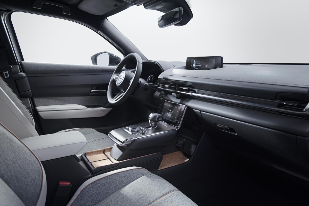 The simple dashboard in the MX-30 features two screens, one ahead of the shifter for climate controls, and one on top of the dash for infotainment