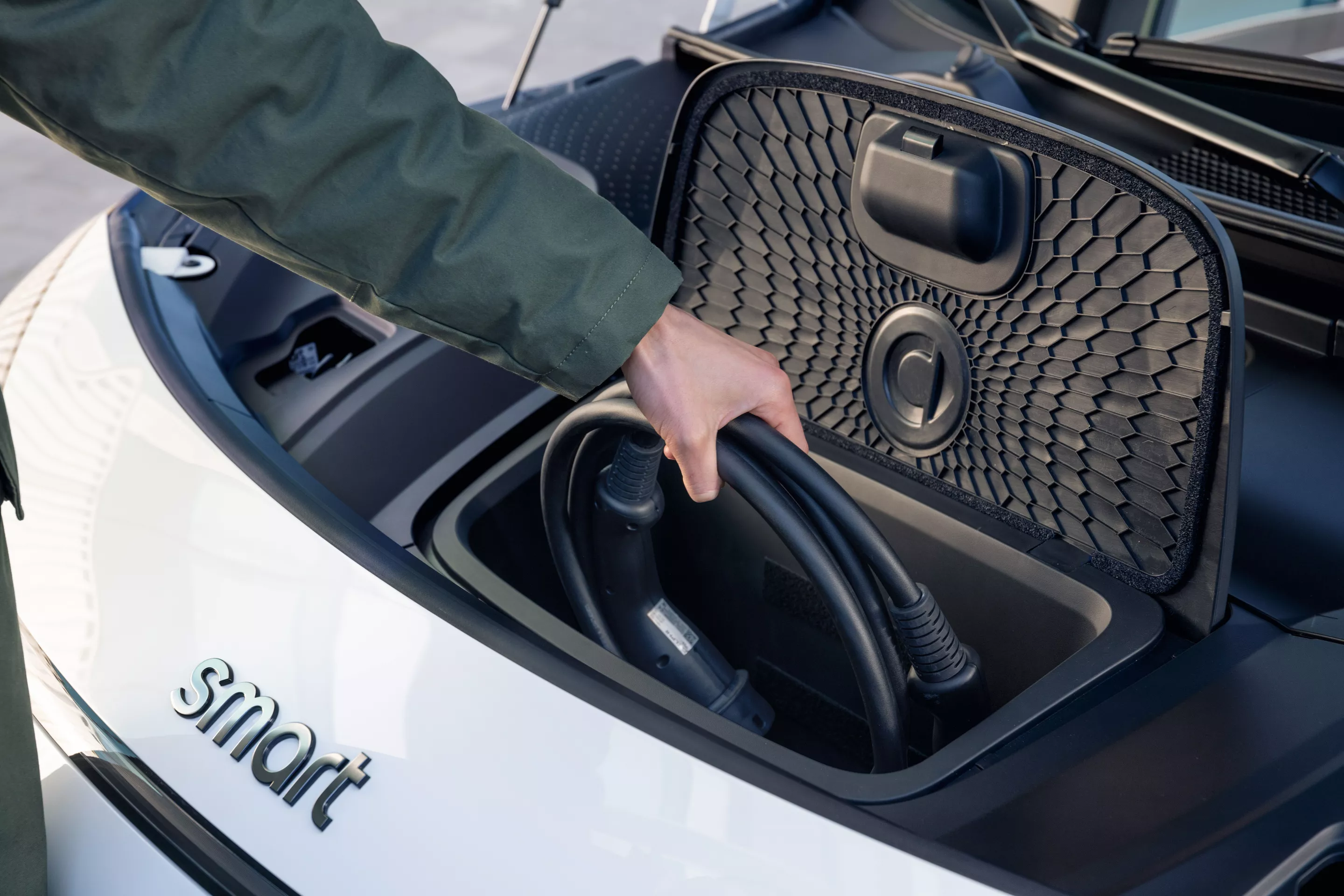 The Smart #1 offers a per-charge WLTP range of up to 273 miles, and the charging cable can be stowed in the frunk