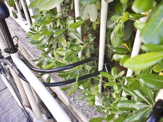 Its two free ends are anchored to a receptacle on the frame while riding, but are then then disconnected and locked around an adjacent immovable object when the bike is parked