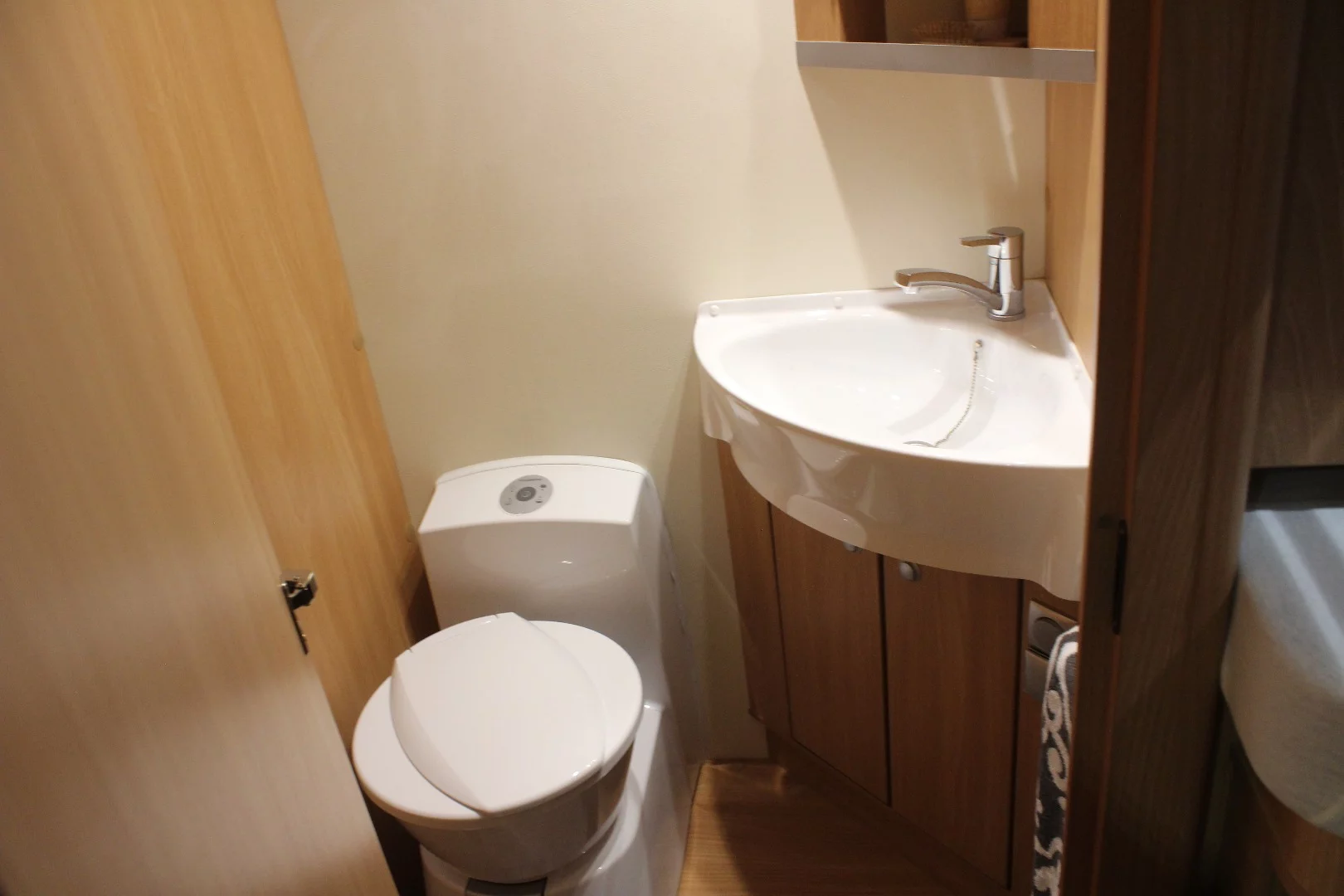 A ceramic toilet and sink in the washroom