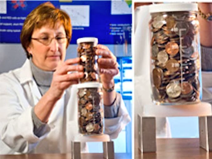 Dr. Meador demonstrating the strength of NASA's new polymer aerogel by stacking many kilograms of coins on a disk supported only at two small areas at its edge (Photo: NASA)