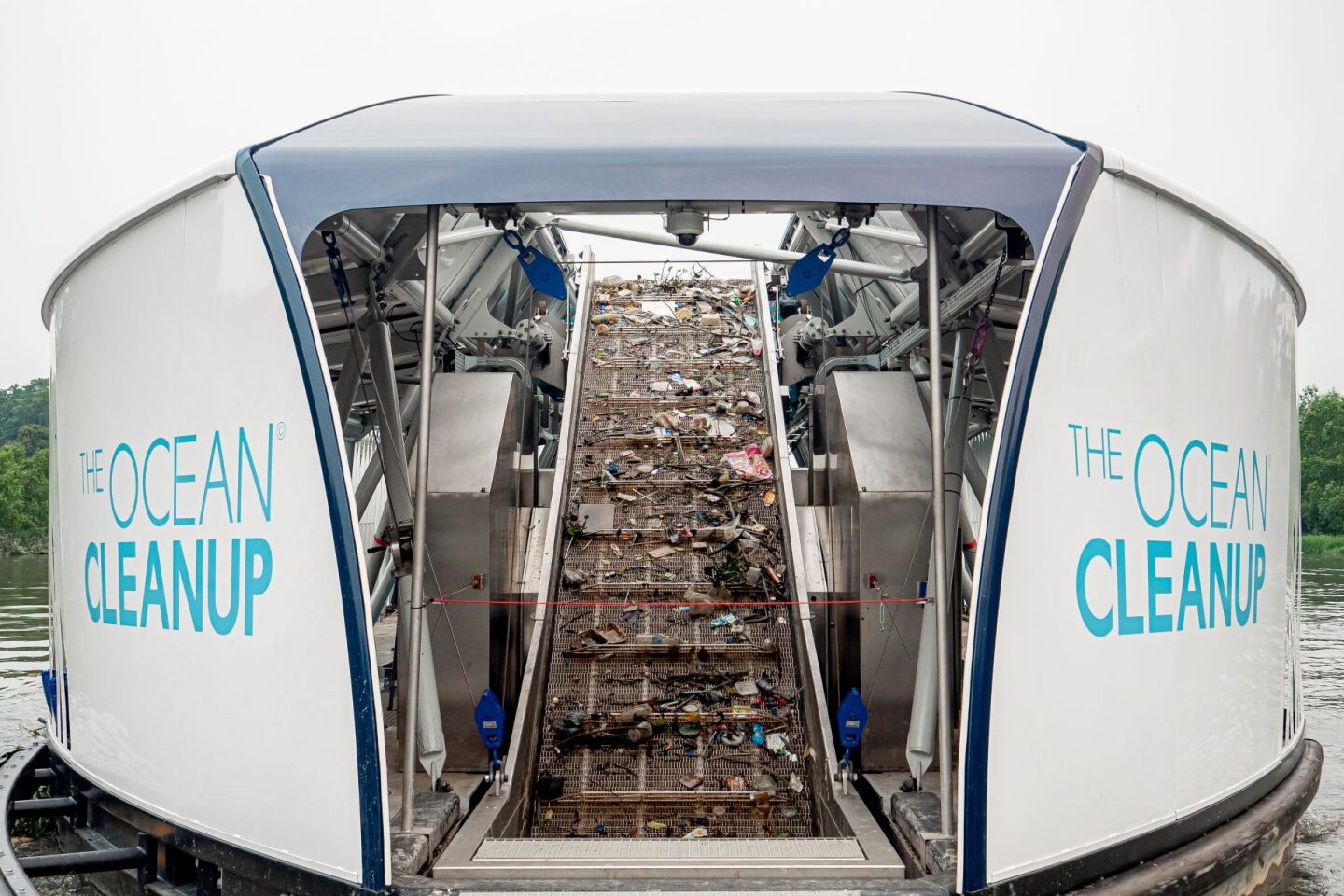 The system is anchored to the riverbed in a position that uses the natural flow of the waterway to push trash towards the mouth of The Interceptor, where it piles onto a conveyor belt