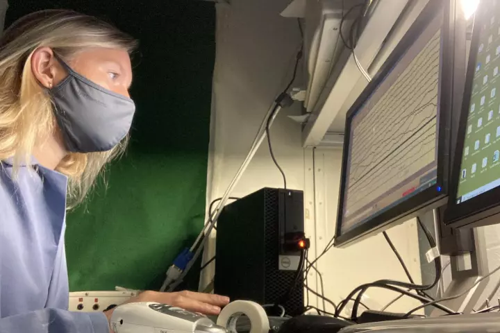 One of the researchers watching brain signals from a sleeping participant in the lab. Researchers are working to expand and refine two-way communications with sleeping people so more complex conversations may one day be possible.