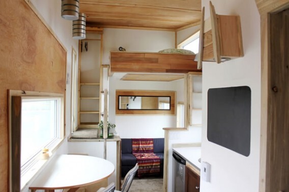 The interior features a living area with sofa bed, raised sleeping quarters and a fully functional kitchen
