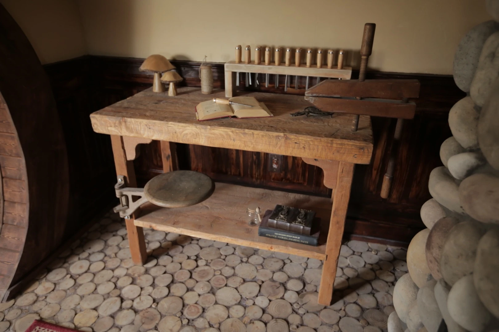 The interior includes authentic-looking touches like a cordwood floor, bespoke lighting, and even a woodworking bench and tools to whittle