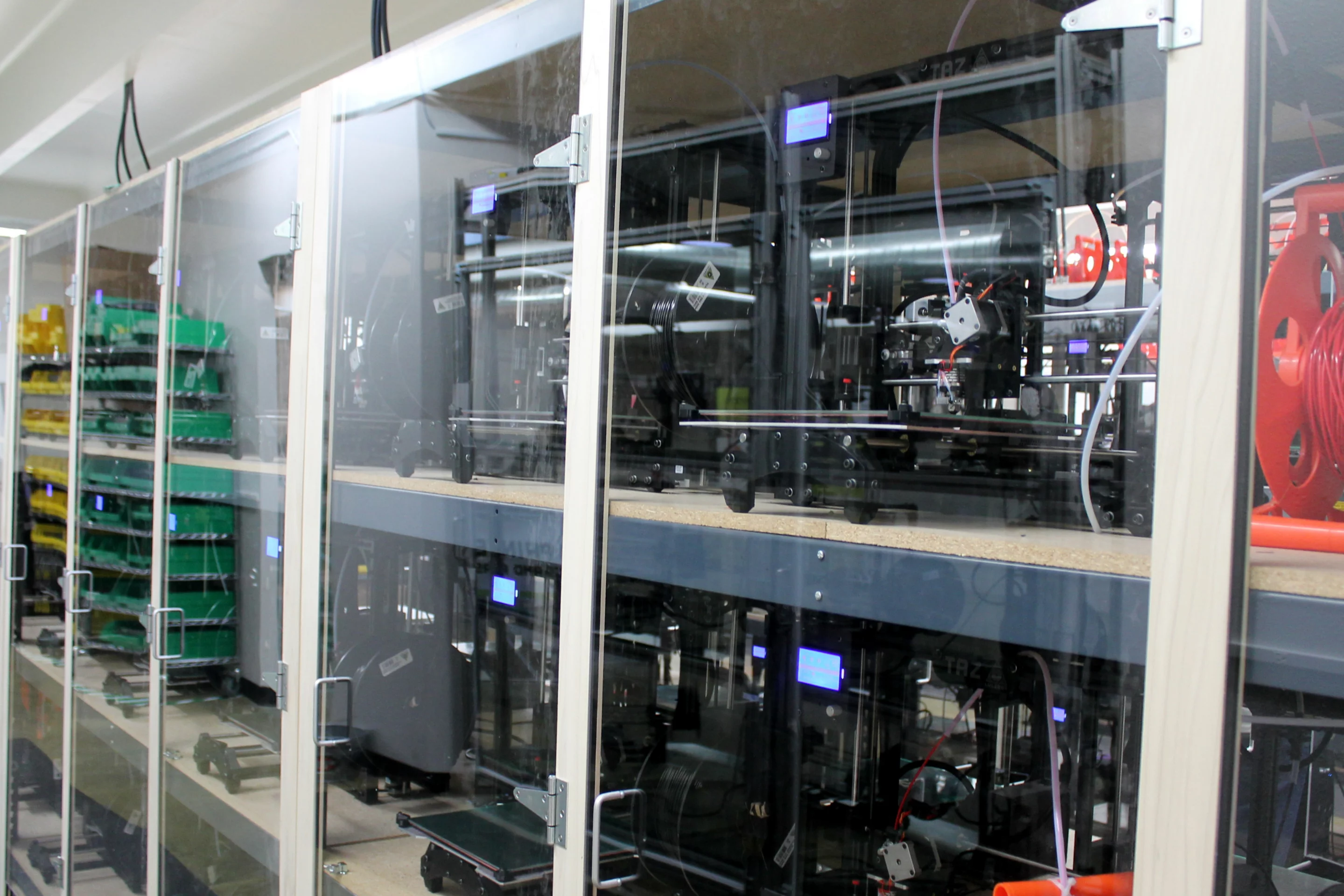 Lulzbot TAZ 3 printers line the cluster room four-deep and three-high