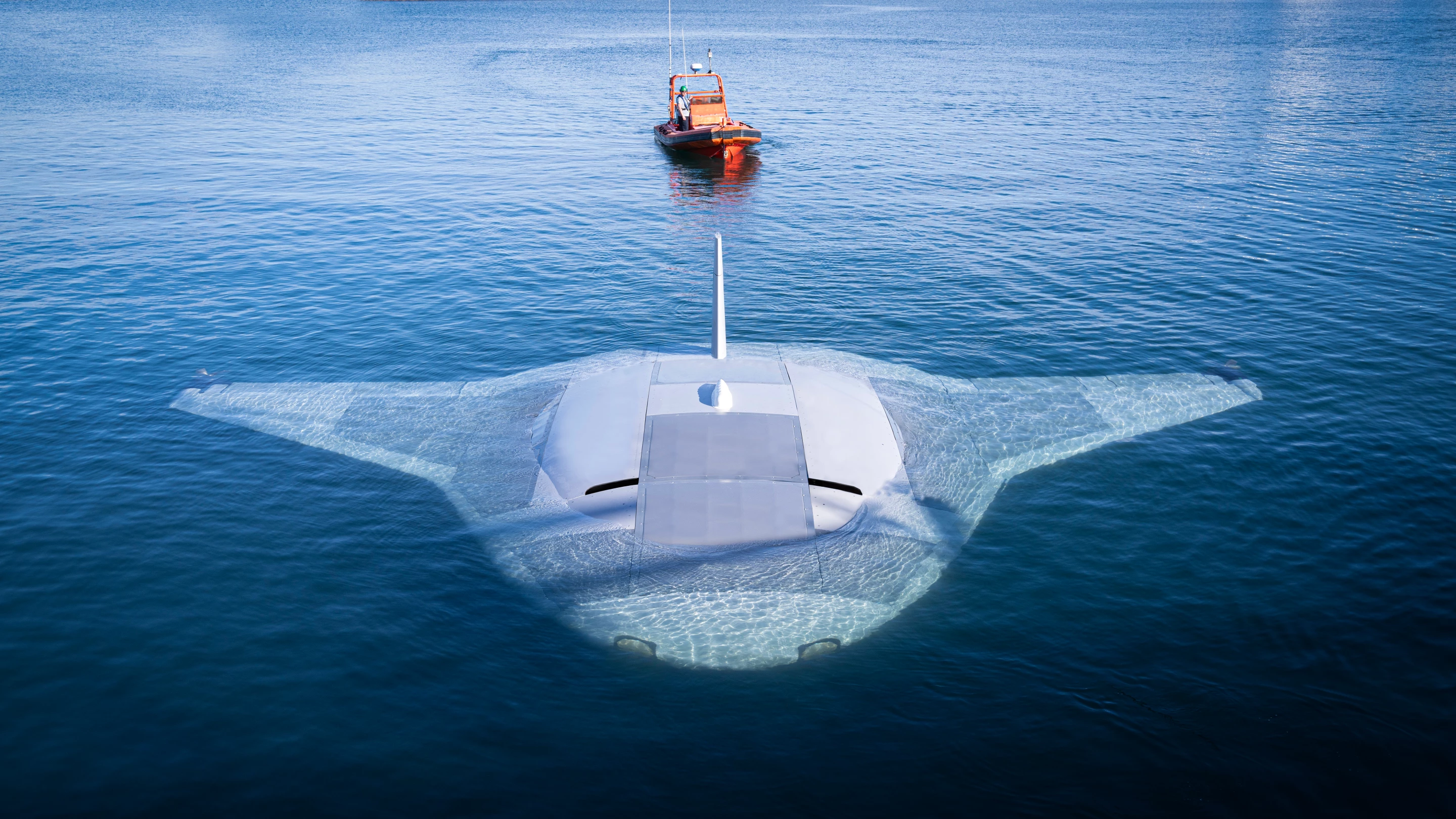 The Manta ray dwarfs a a small work boat behind it