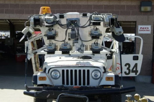 Indy Robot Racing’s 2005 Jeep Rubicon uses a combination of LIDAR and RADAR sensors, structural light detectors, mounted road-following cameras and a drive-by-wire system.