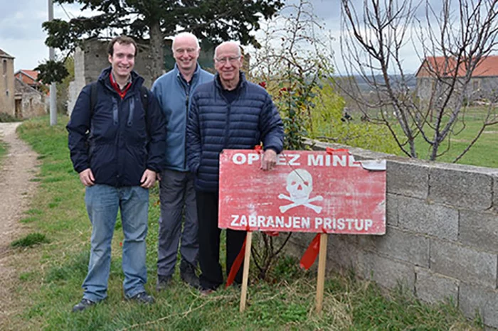University of Bristol researchers Dr Oliver Payton and Dr John Day with Sir Bobby Charlton on a visit to mine clearance operations in Croatia