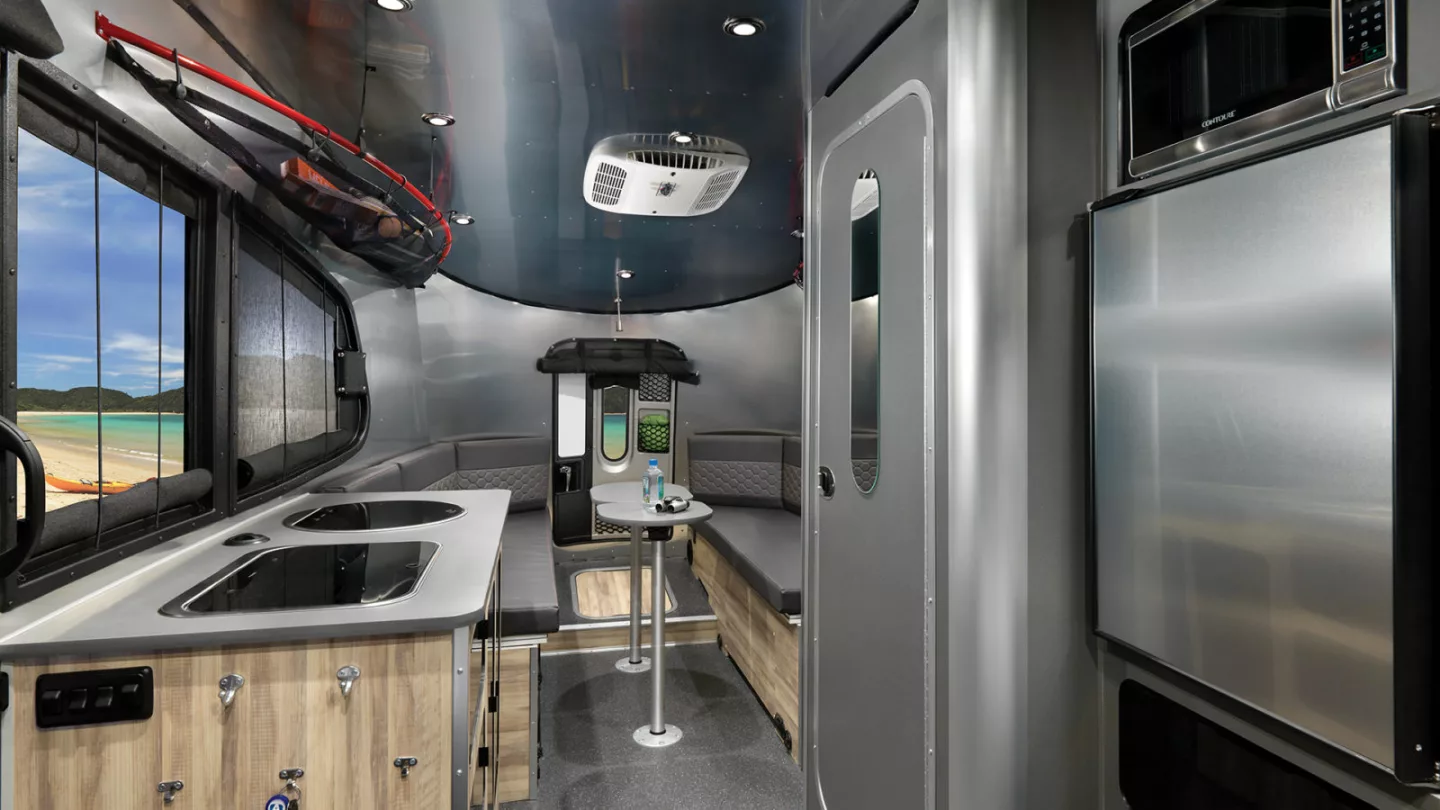 The Airstream 20 includes a central kitchen and wet bath and a rear dining lounge/convertible bed with two removable tables