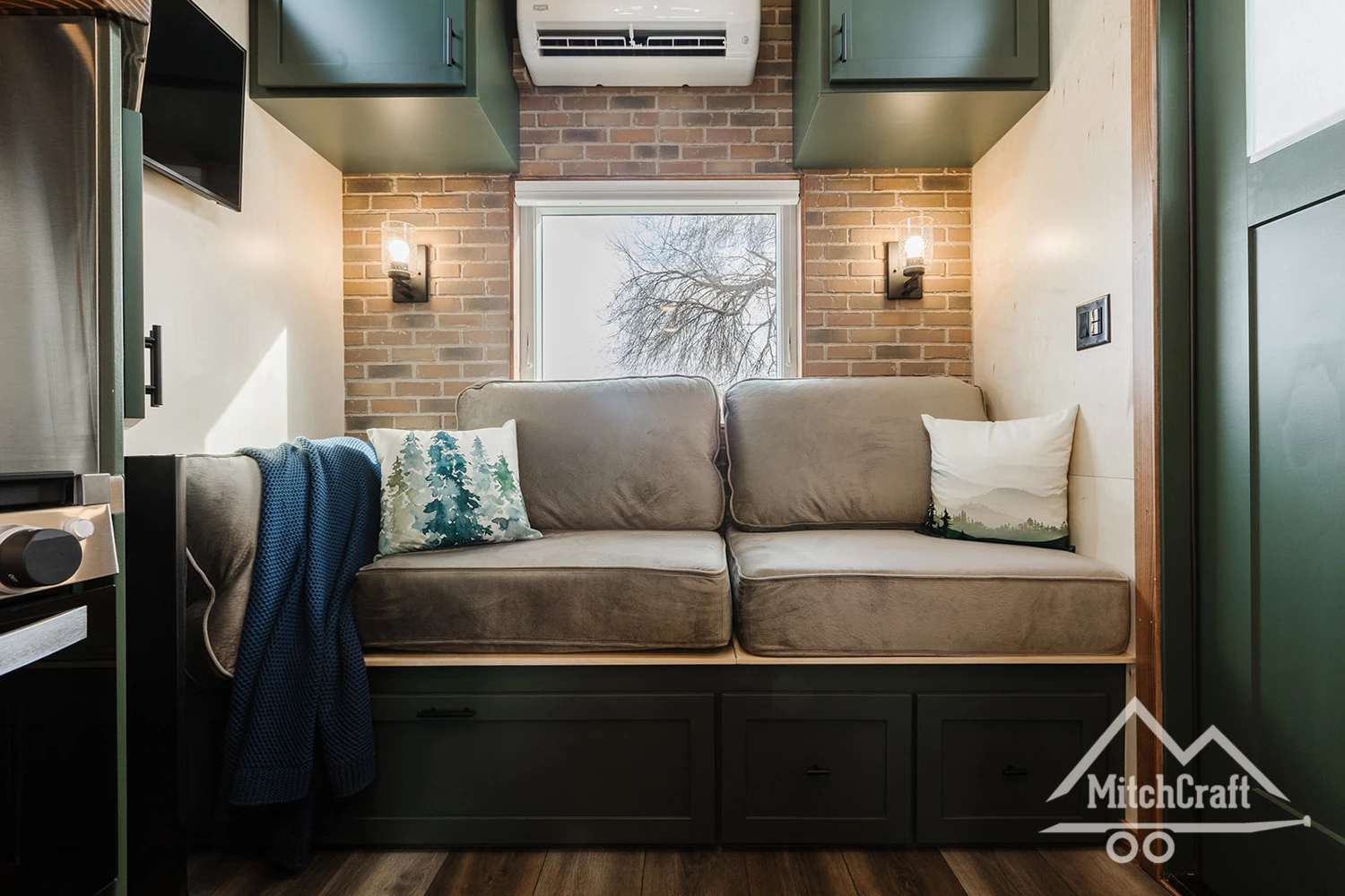 Visitors enter into the living room, which is very snug and contains a sofa and some storage space