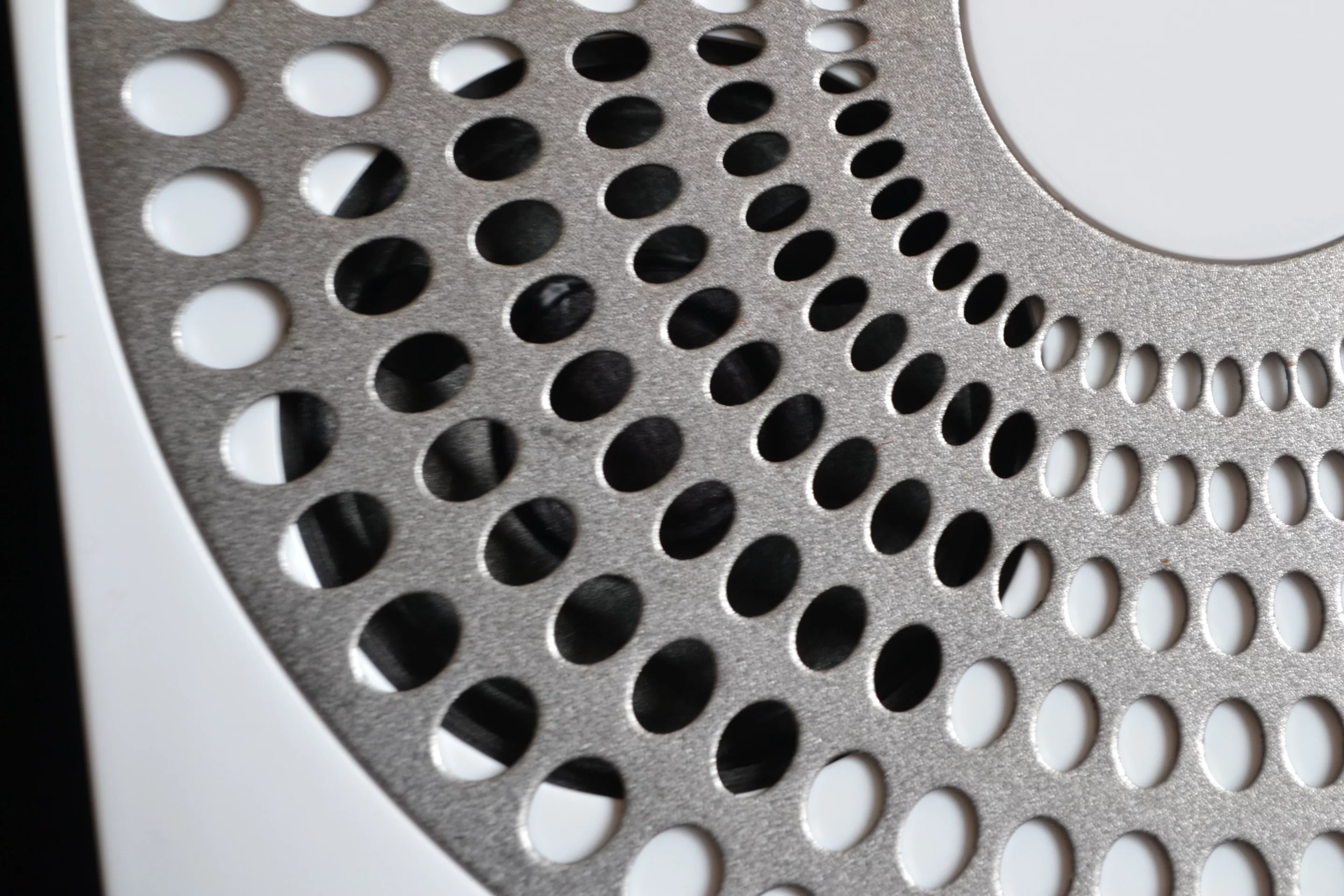 Close up of one of Ubi's speakers behind the metal grille