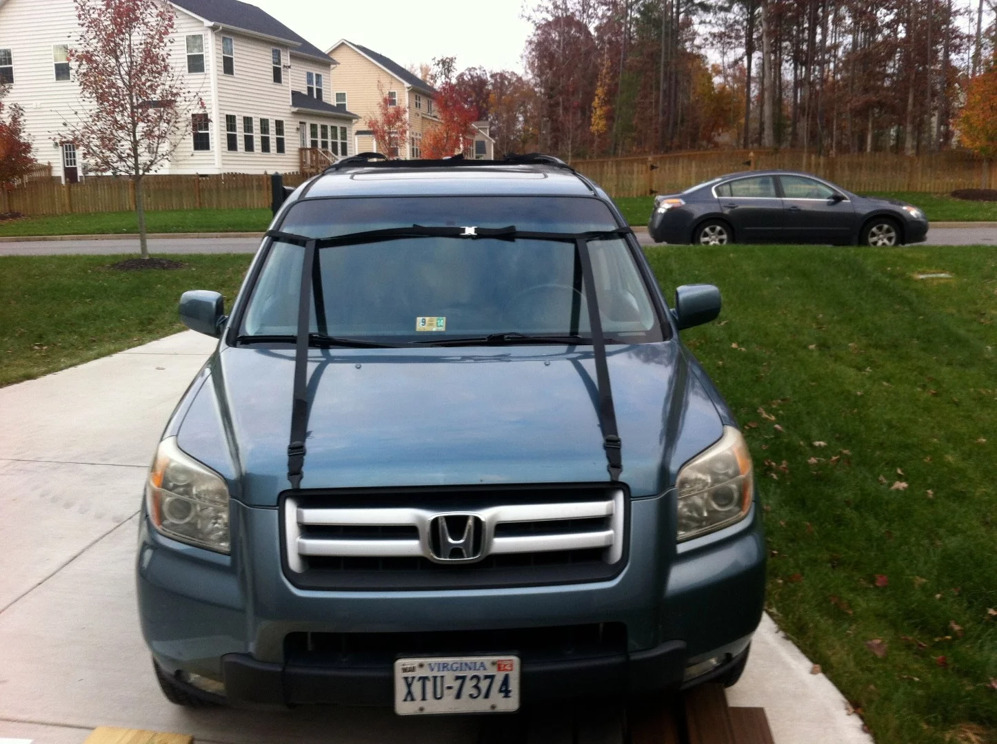 The front straps wrap around the windshield and anchor on the hood
