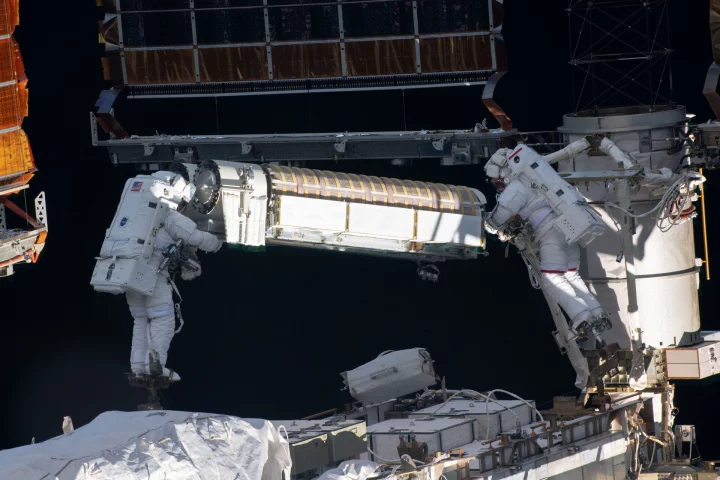 Astronauts Thomas Pesquet and Shane Kimbrough seen transporting one of the new solar arrays to the installation point