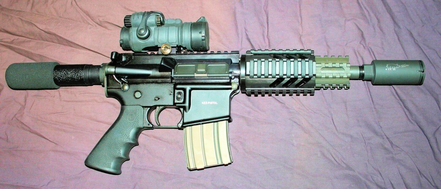 Olympic Arms K23 AR-15 pistol with a 6.5 inch barrel equipped with a sight and a flash suppressor. The tube extending from the back of the pistol is the receiver extension, within which the bolt of the firearm's action travels back and forth (Photo: Steven Z via Wikimedia Commons)