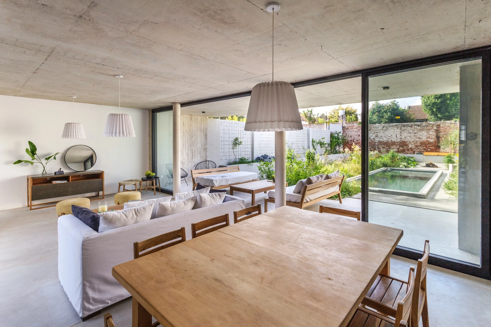 The MeMo House's unfinished concrete interior is softened with greenery and soft wood