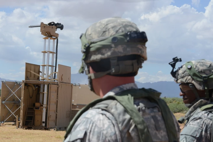 Lieutenant Colonel Raphael Heflin, right, commander, 142nd Combat Service Support Battalion, 1st Armored Division, and another soldier pass near a remotely-controlled weapons system