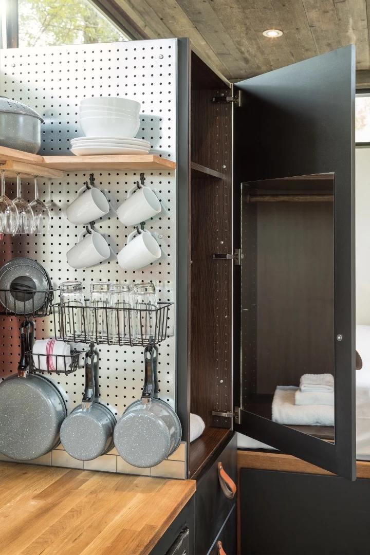 The RoadHaus' kitchenette includes a fridge/freezer, microwave, two-burner stove, sink, cupboard space, and shelving
