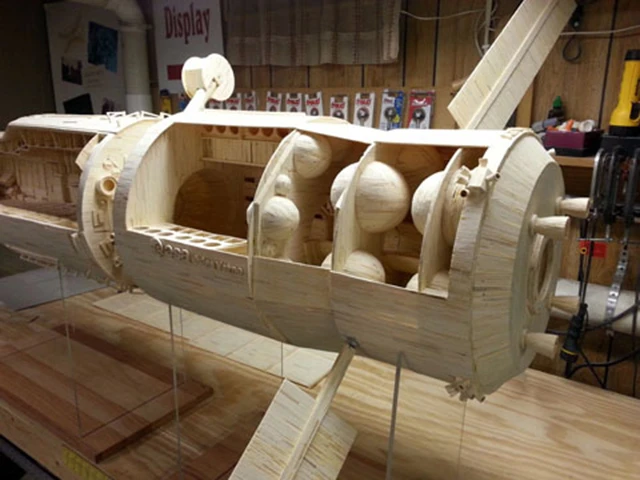 The two cutaway models show interior details, such as science racks, work areas, toilets, sleeping areas, storage spaces, and computer stations