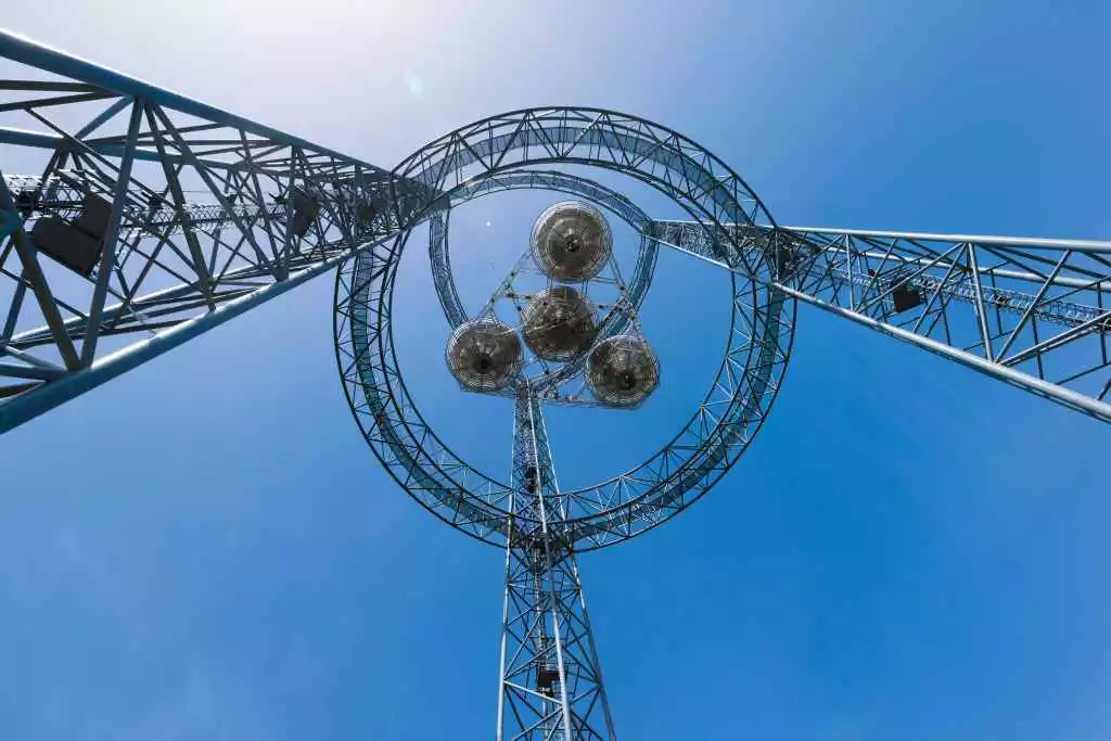 The 75 meter-tall tower holds up a mock satellite capable of tracking the Sun, concentrating solar energy, converting it into electricity, then converting it again into microwaves and beaming it to a rectenna on the ground some 55 meters below
