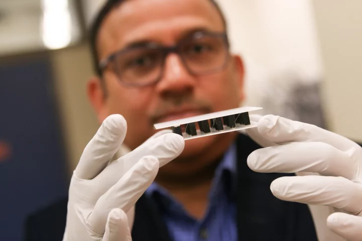 Ashutosh Tiwari holds up a sample of his team's thermoelectric material, which can generate electricity from a temperature difference without using toxic elements