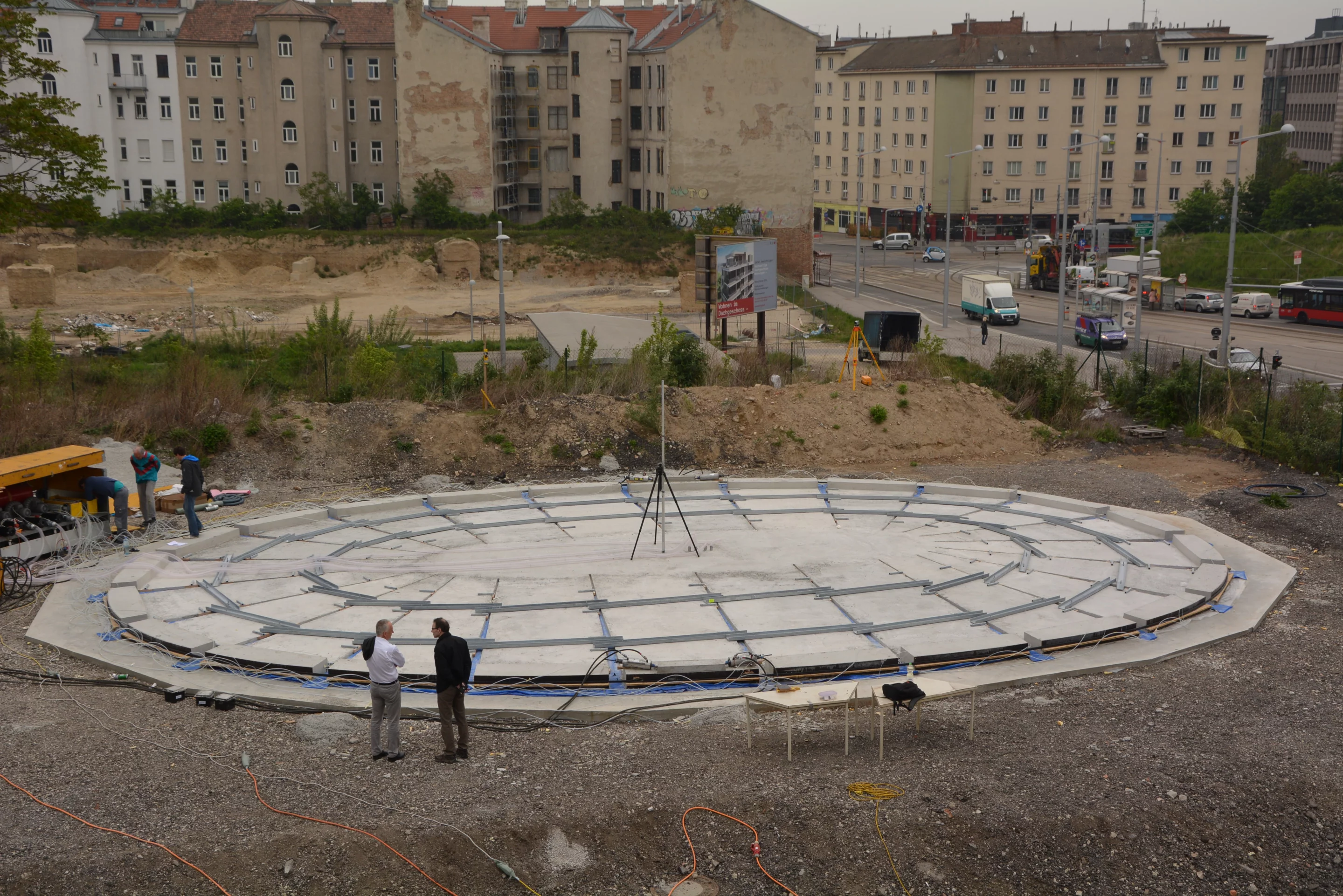 Metal beams and a steel cable are subsequently attached to those slabs, linking them all together