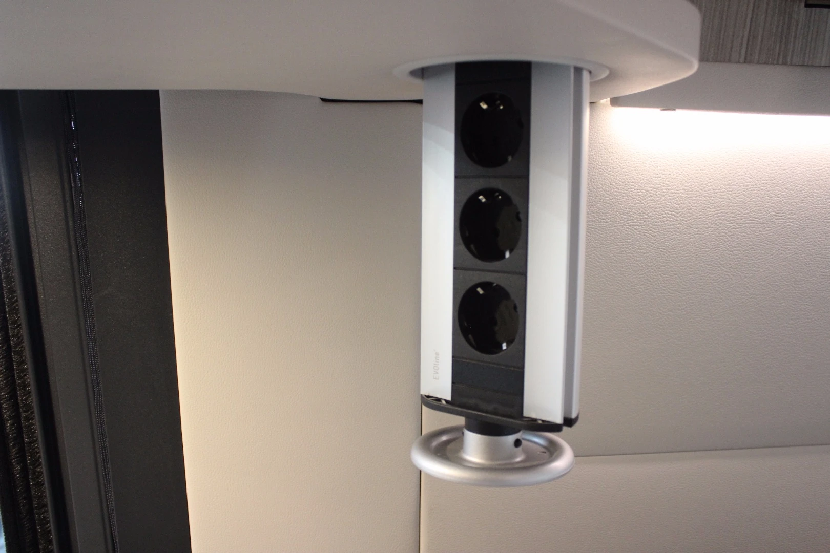 One of our favorite components on the Roadtrip Sprinter camper van, the pull-down electrical receptacle over the kitchen provides power when you need, disappears when you don't