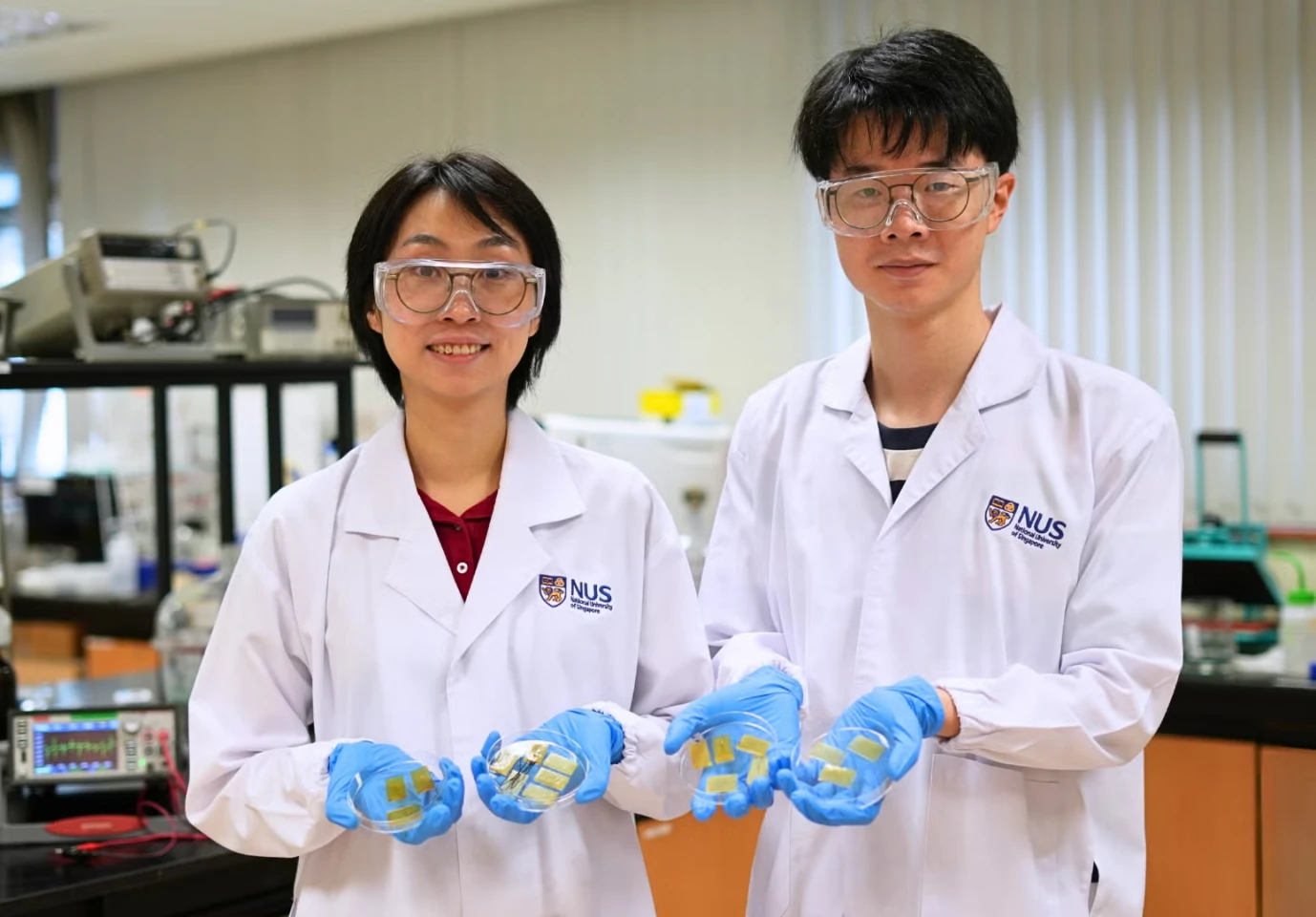 Asst Prof Tan Yu Jun (left), PhD student Mr Zhou Jinrun (right), displaying their self-healing electronic skin that can detect touch and damage, and repair itself even underwater