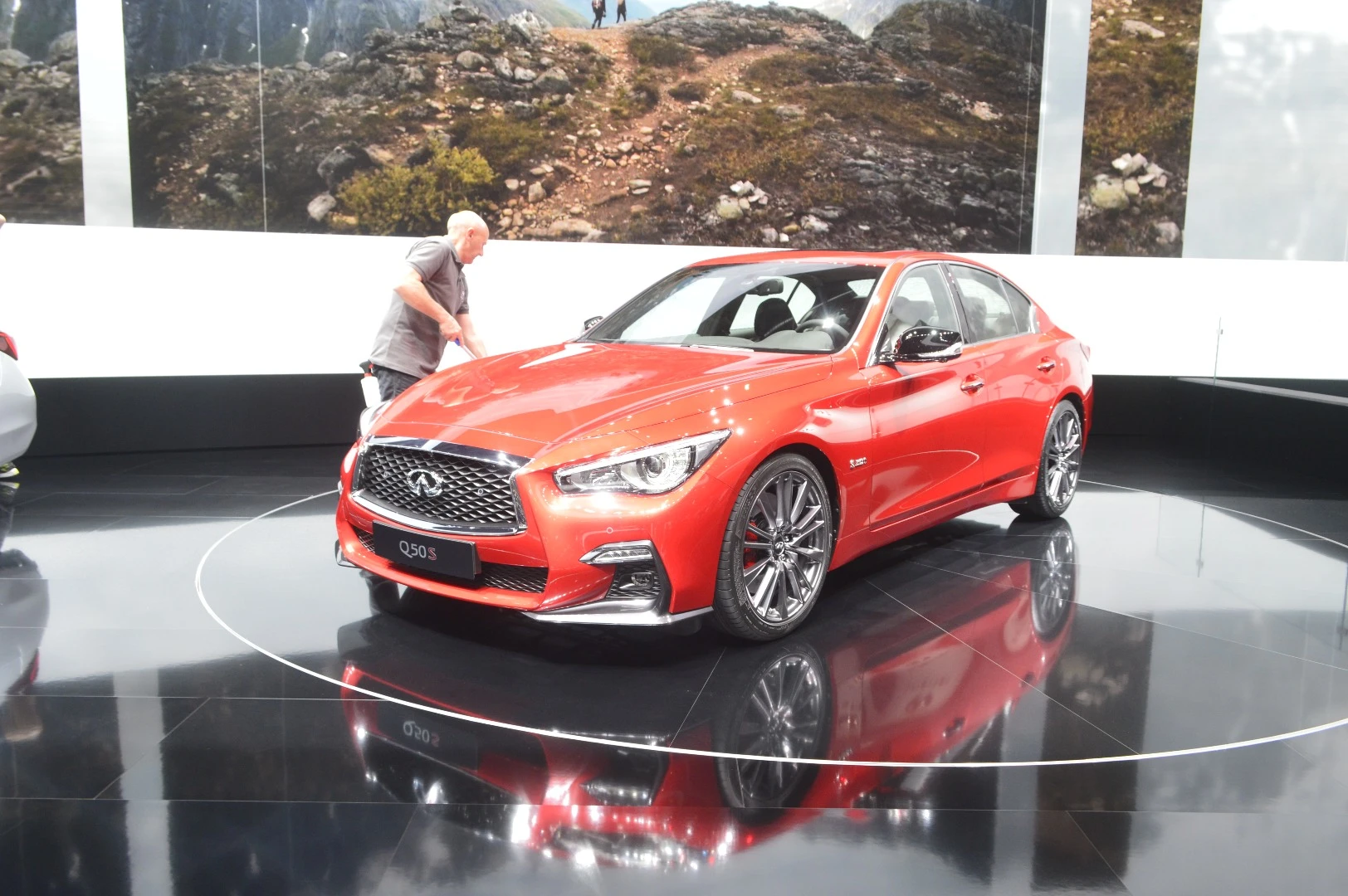 On the 2018 Infiniti Q50 Red Sport 400, dark metallic trim around the exhaust cutouts on the bumper match the exclusive high-gloss black paint on the side mirror caps