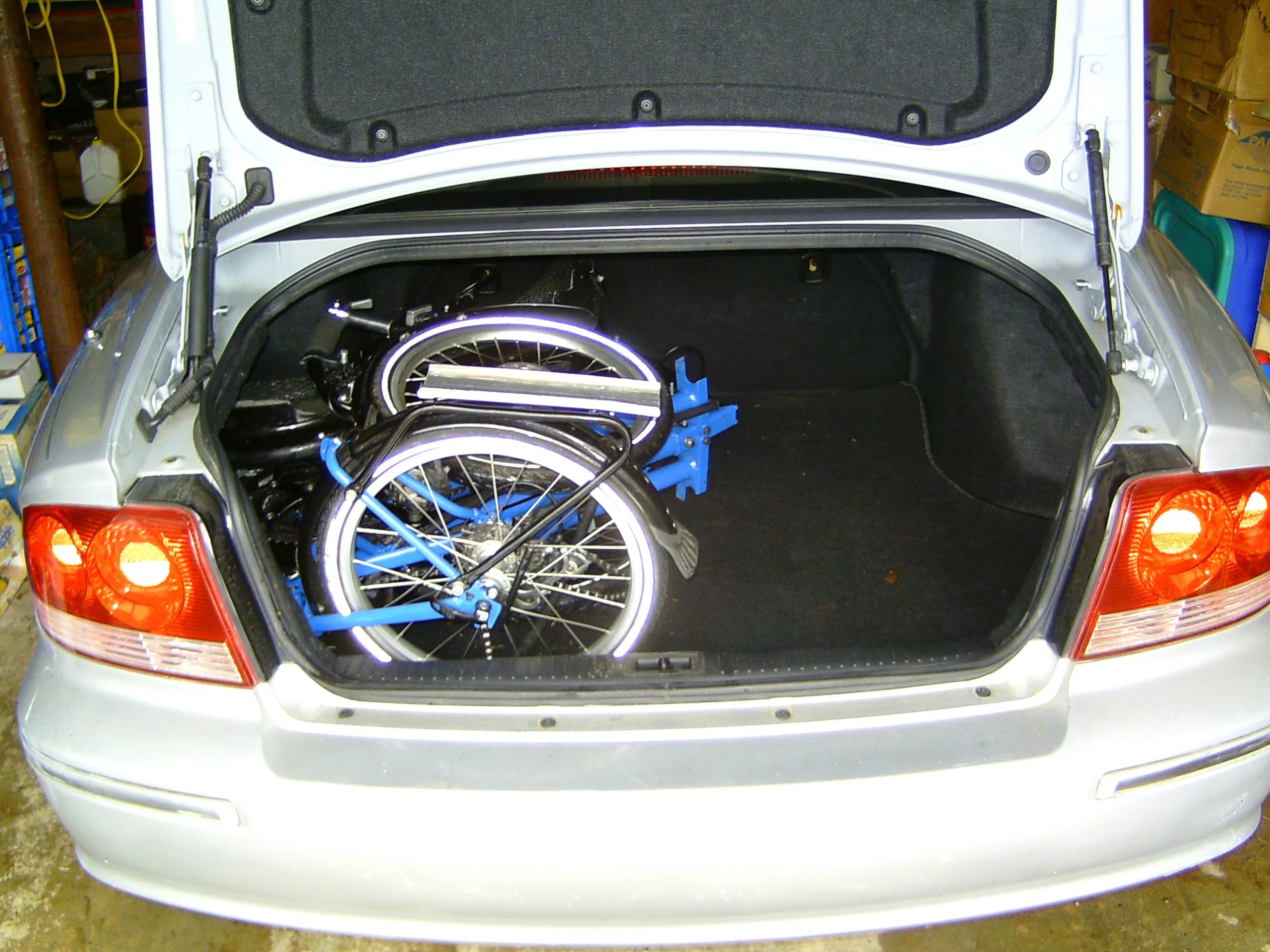 The Evolve trike, folded and in the trunk of a car
