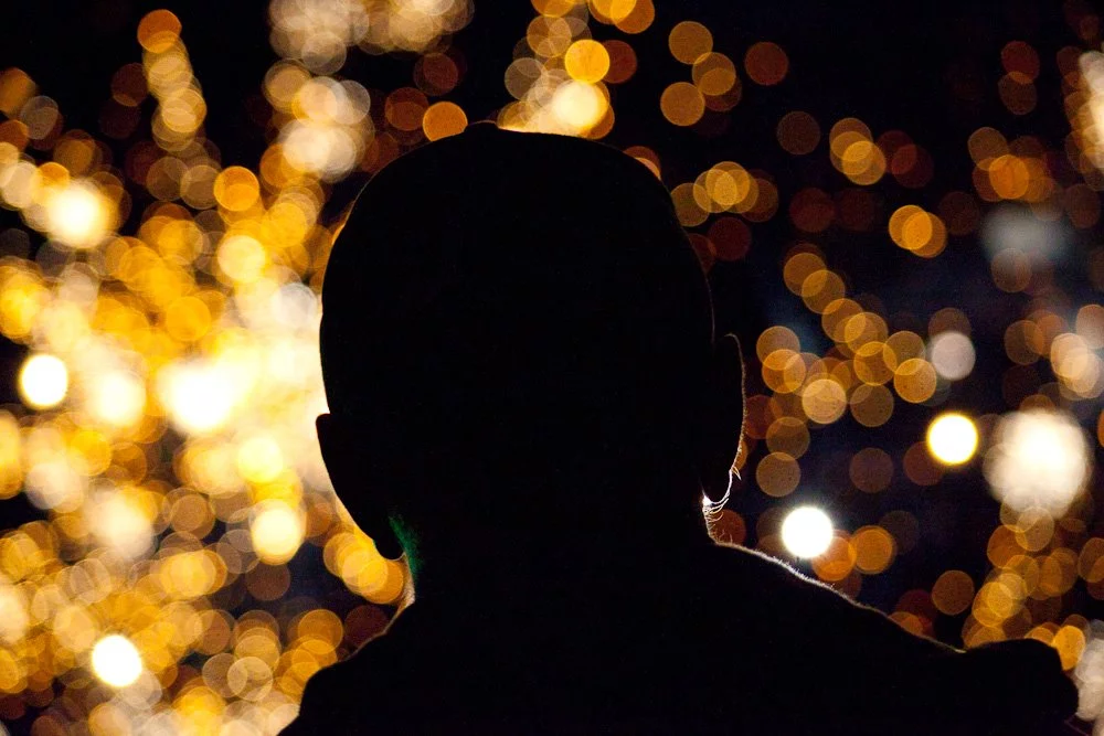 Using the fireworks as a dramatic, backlighting background. Shot using wide aperture, focused on the head.