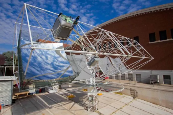 A dish-shaped mirror focuses sunlight onto a glass ball, which distributes it evenly onto an array of photovoltaic cells (Photo: Blake Coughenour/UA)