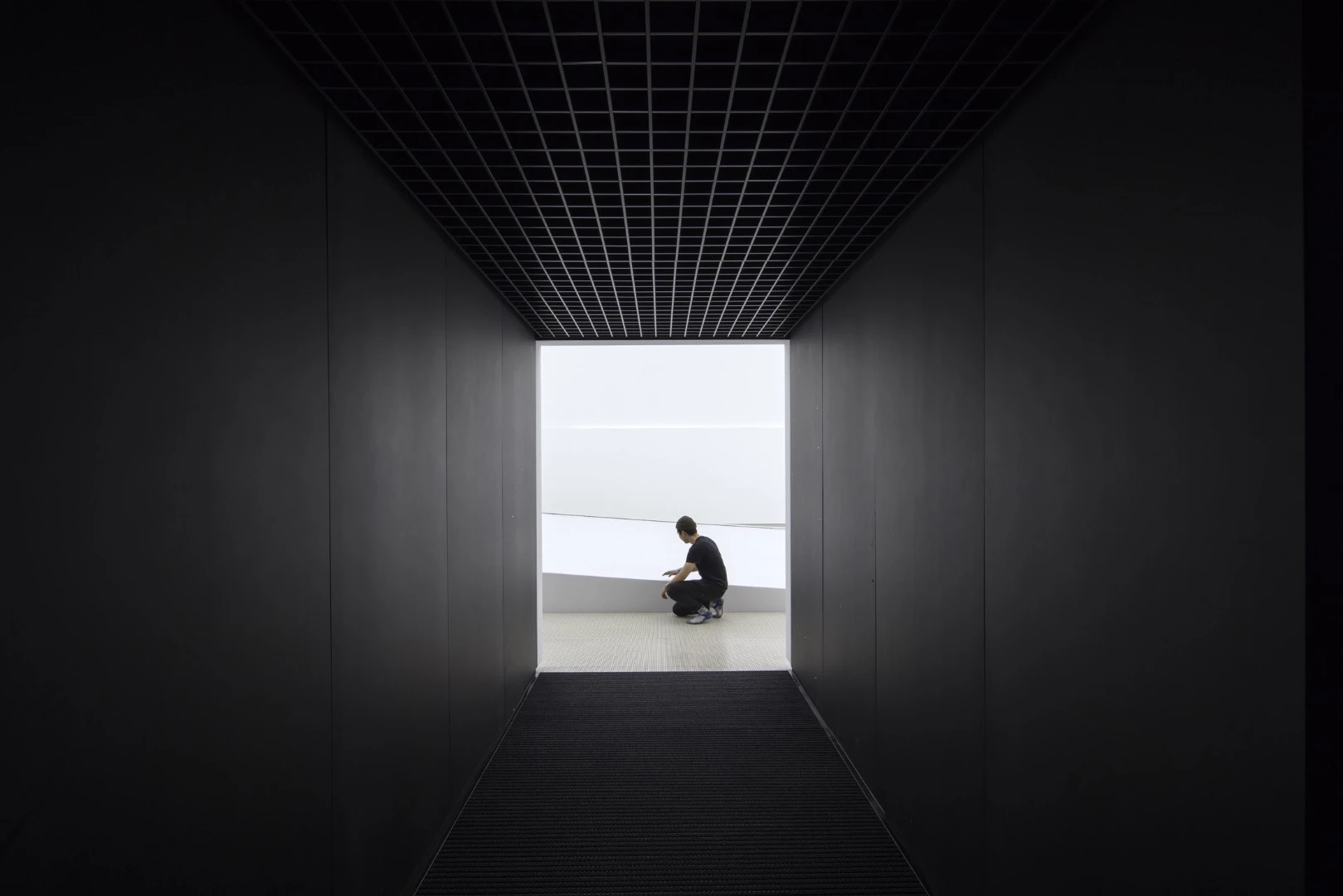 The hallway a visitor travels through to enter the white inside of the pavilion