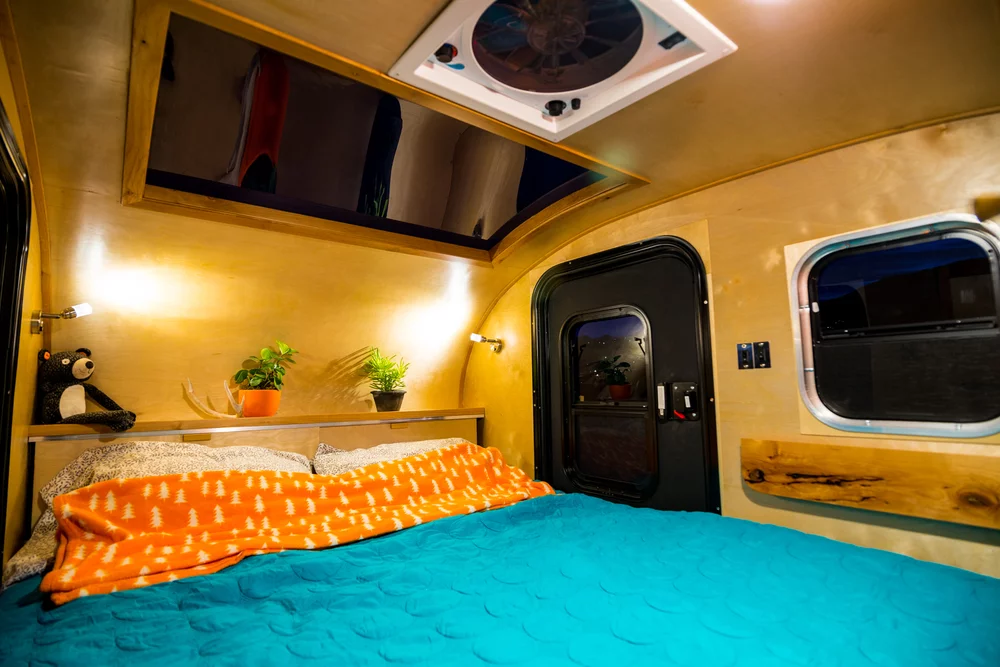 There are wooden storage compartments at the head and foot of the bed