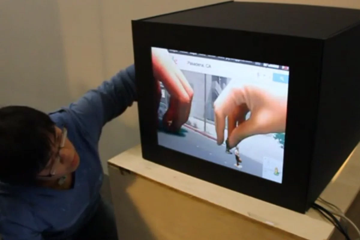 With Portal boxes, two people connected to the internet can literally reach behind a video screen to interact with the virtual world inside together