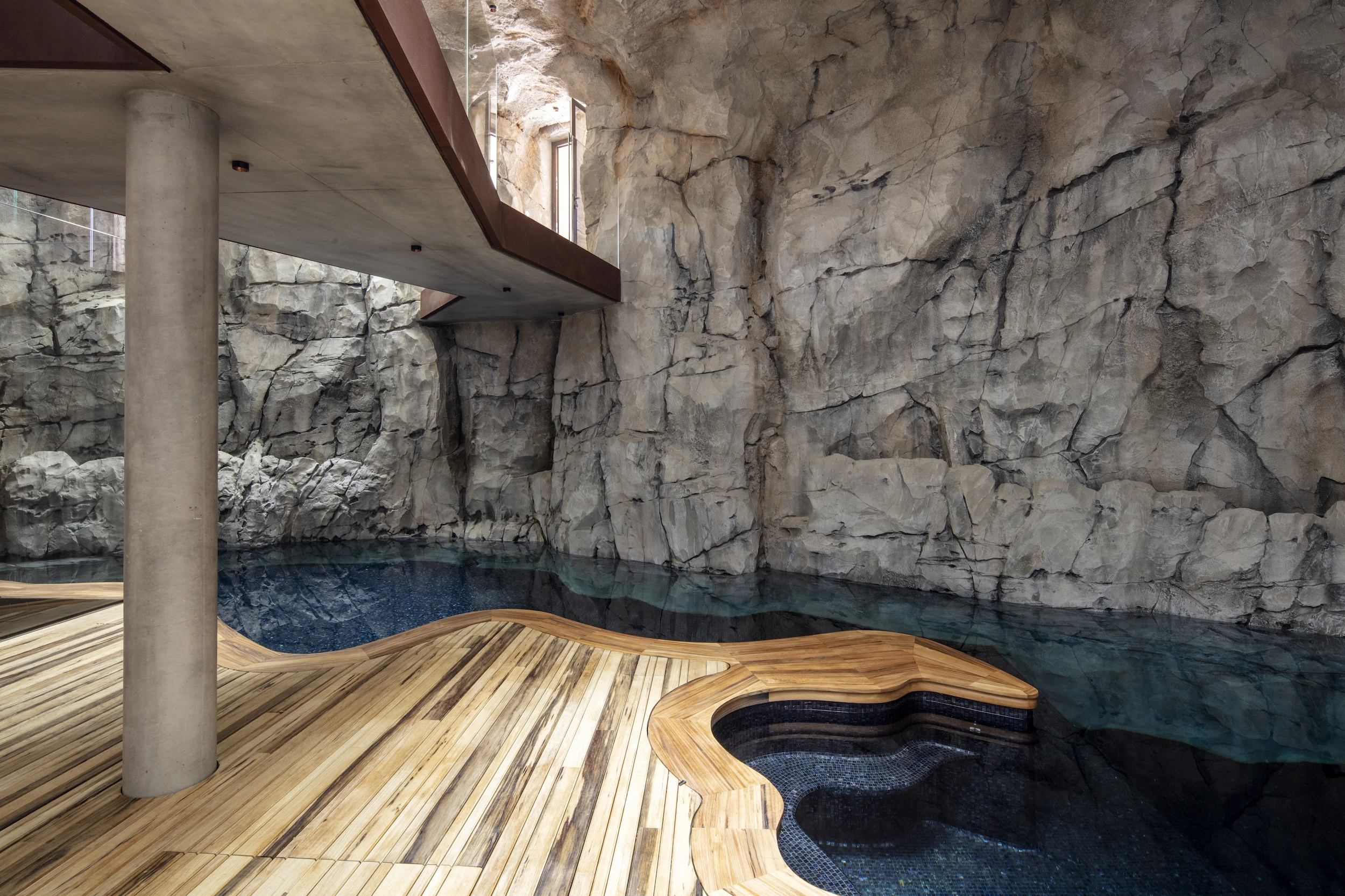 Visitors enter Villa Troglodyte into a pool/reception area. A car garage with electric charging station is also nearby